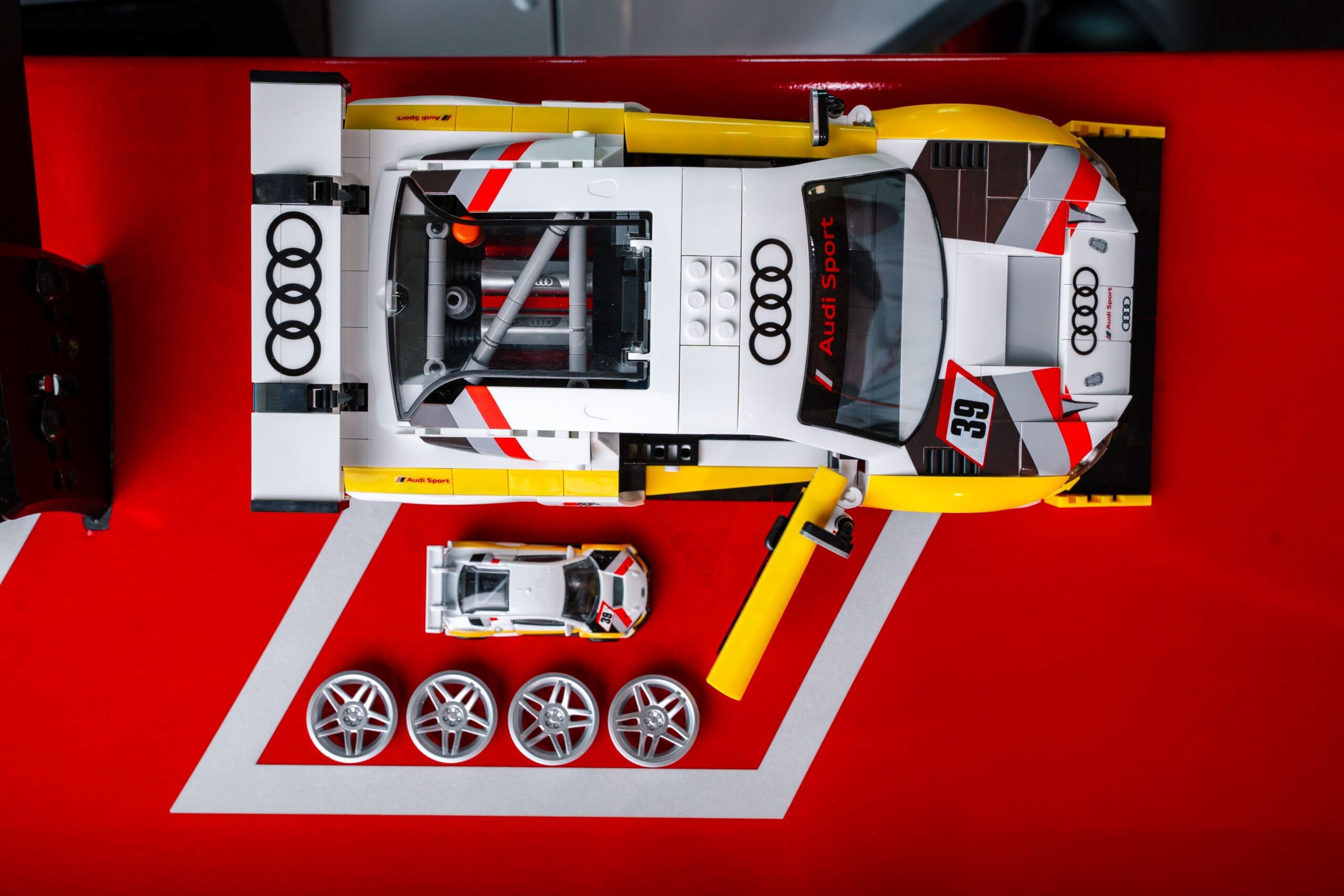 A photo of the Audi R8 LMS racecar in both Hot Wheels and Mattel Brick Shop forms.