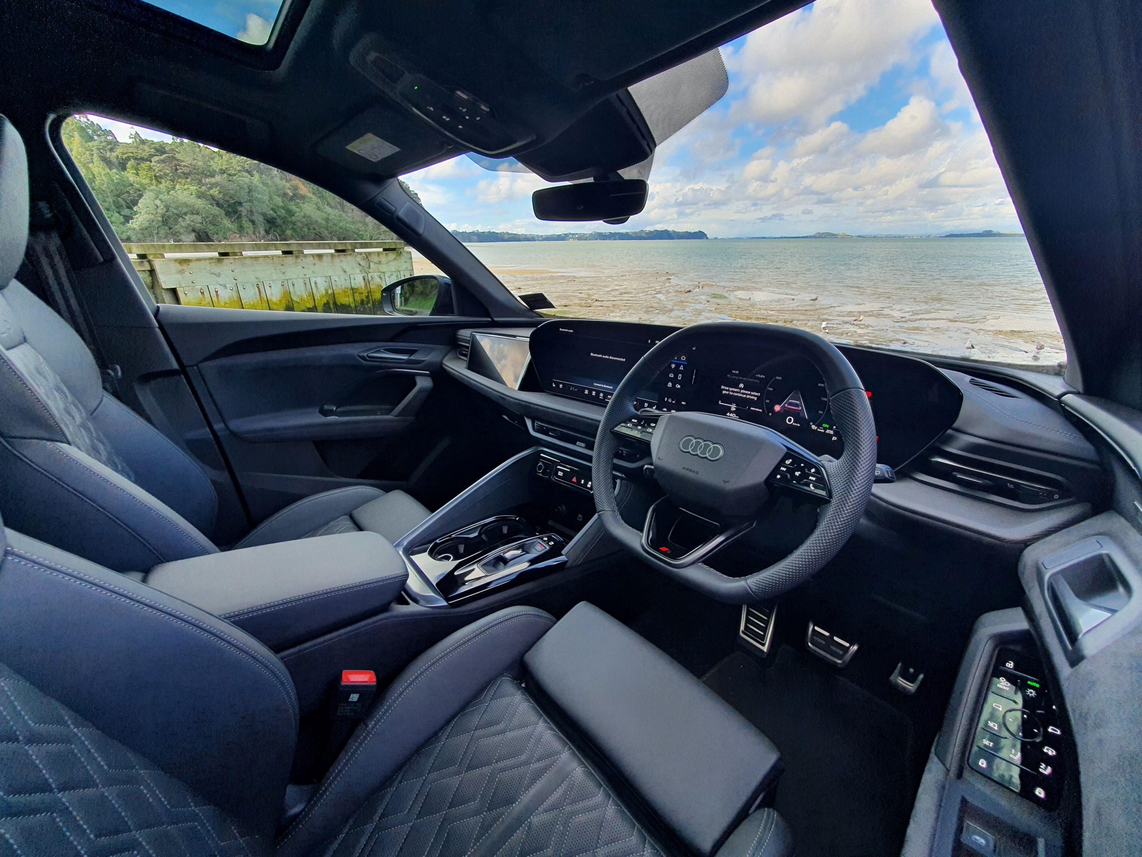 Interior view of a 2025 Audi SQ5 with the ocean visible through the windscreen.