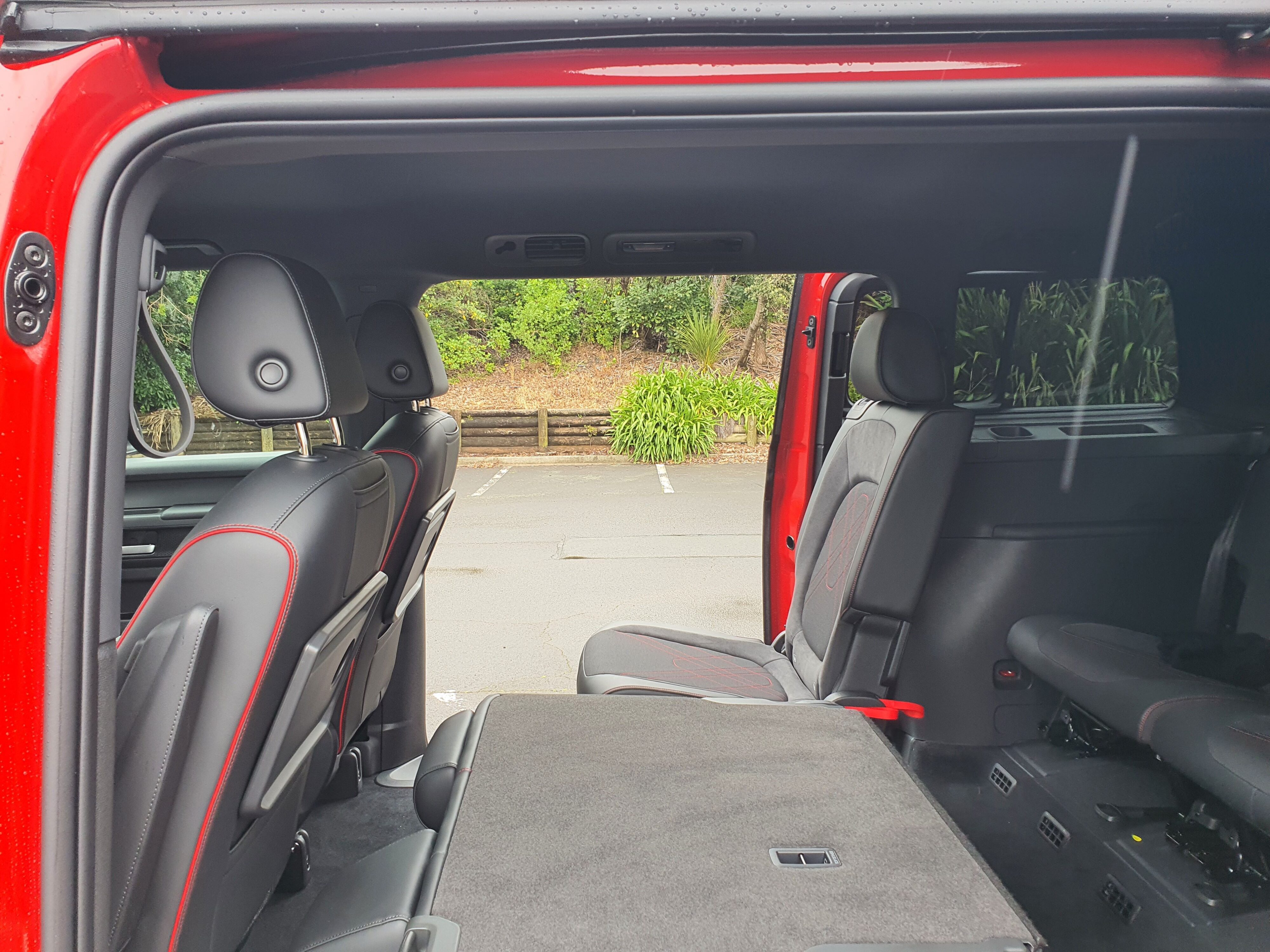 Side on view of a 2025 Volkswagen ID.Buzz GTX in red and silver with the doors open.