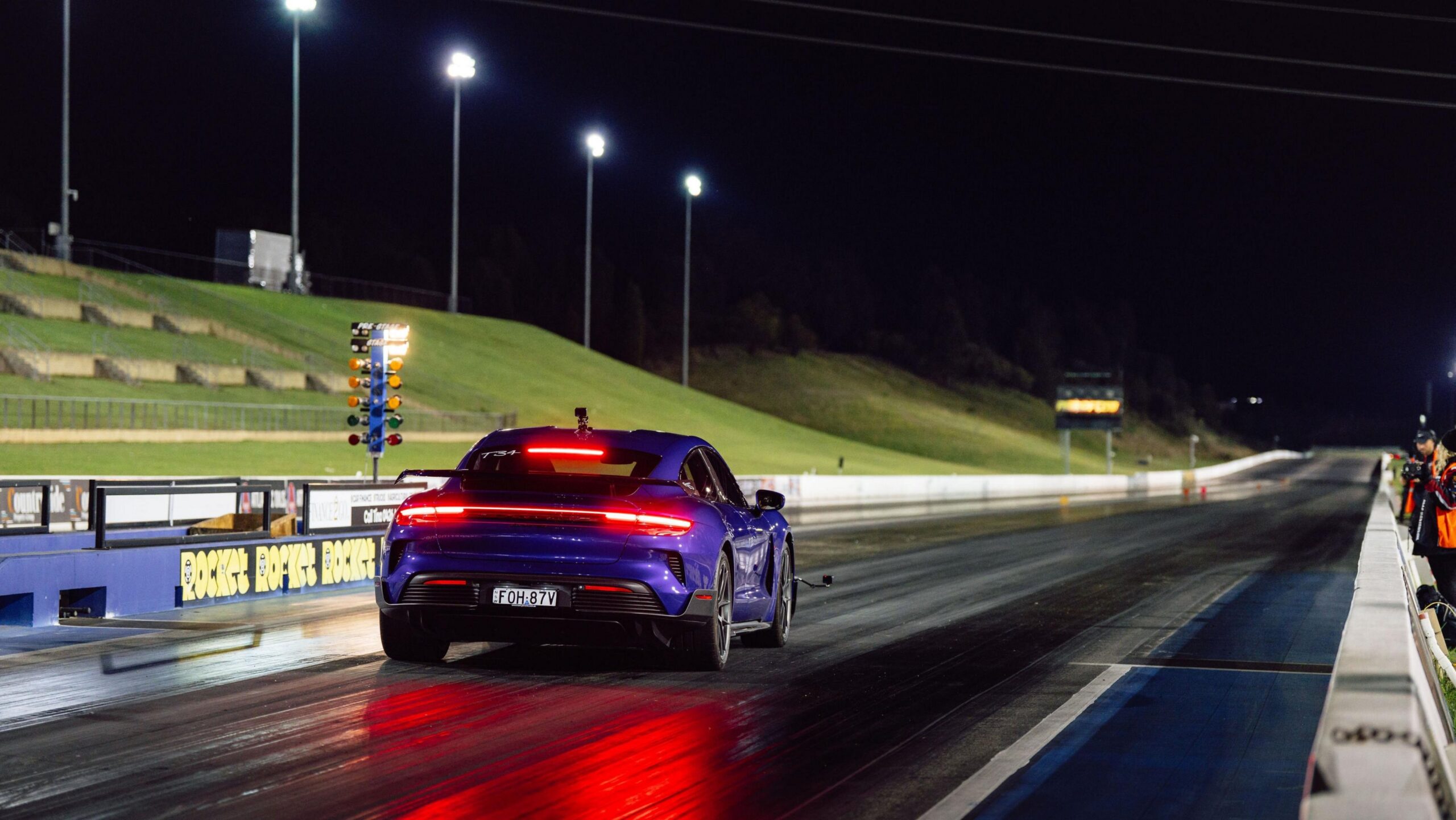 Rear three quarters view of a purple Porsche Taycan Turbo GT at Sydney Dragway.