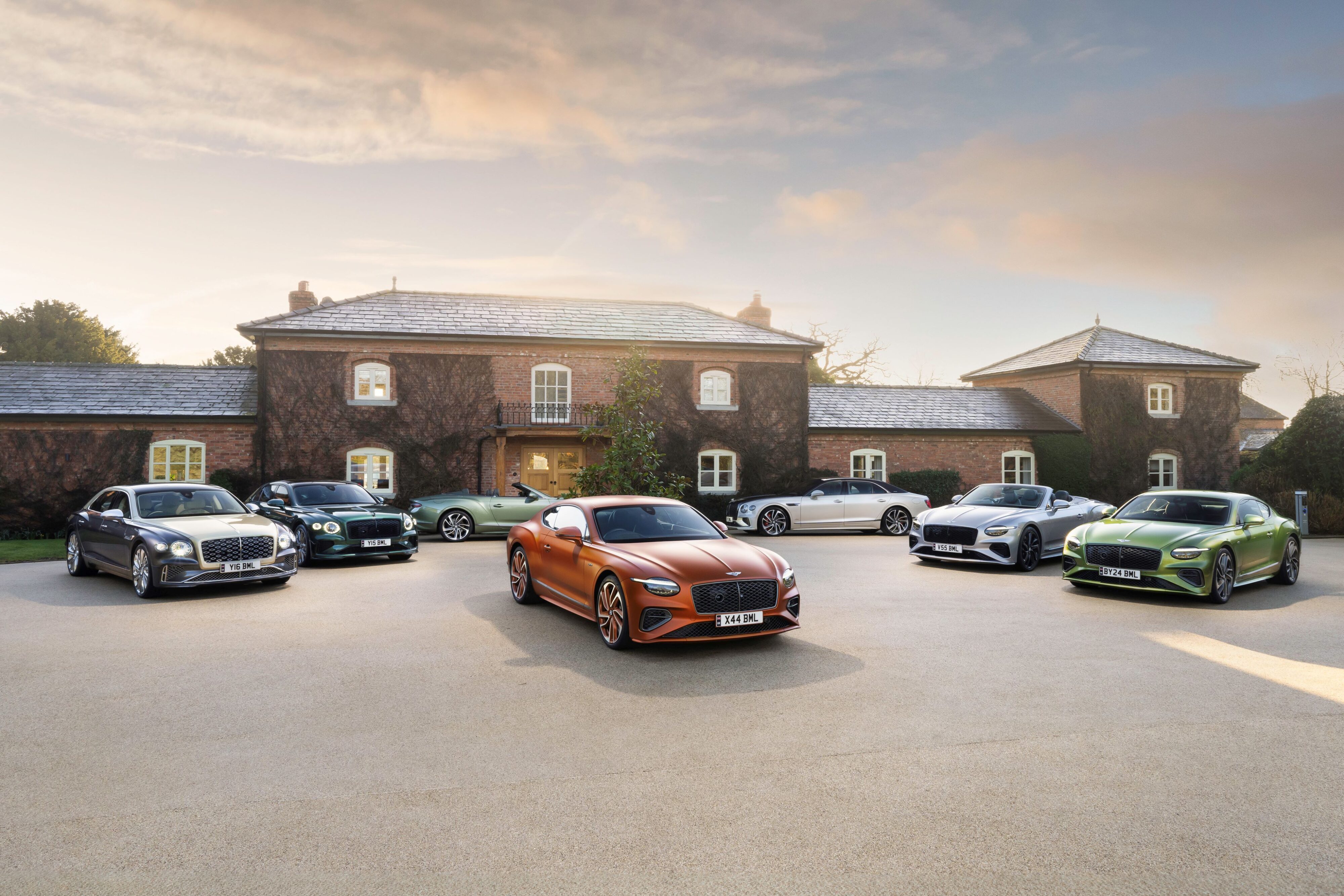 A photo of a collection of modern Bentleys in the driveway of a lavish property.