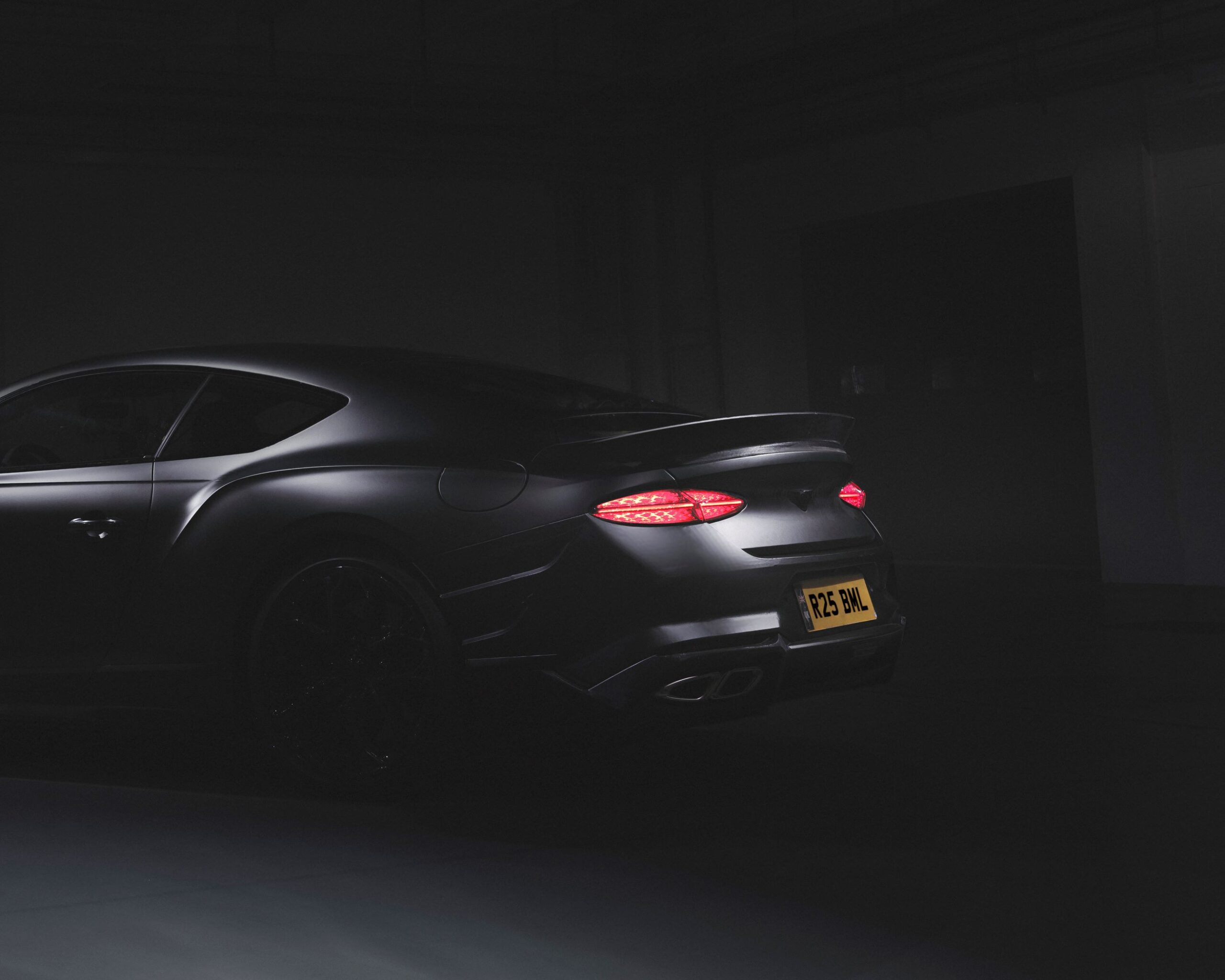 Teaser image of a matte black Bentley Continental Supersports.