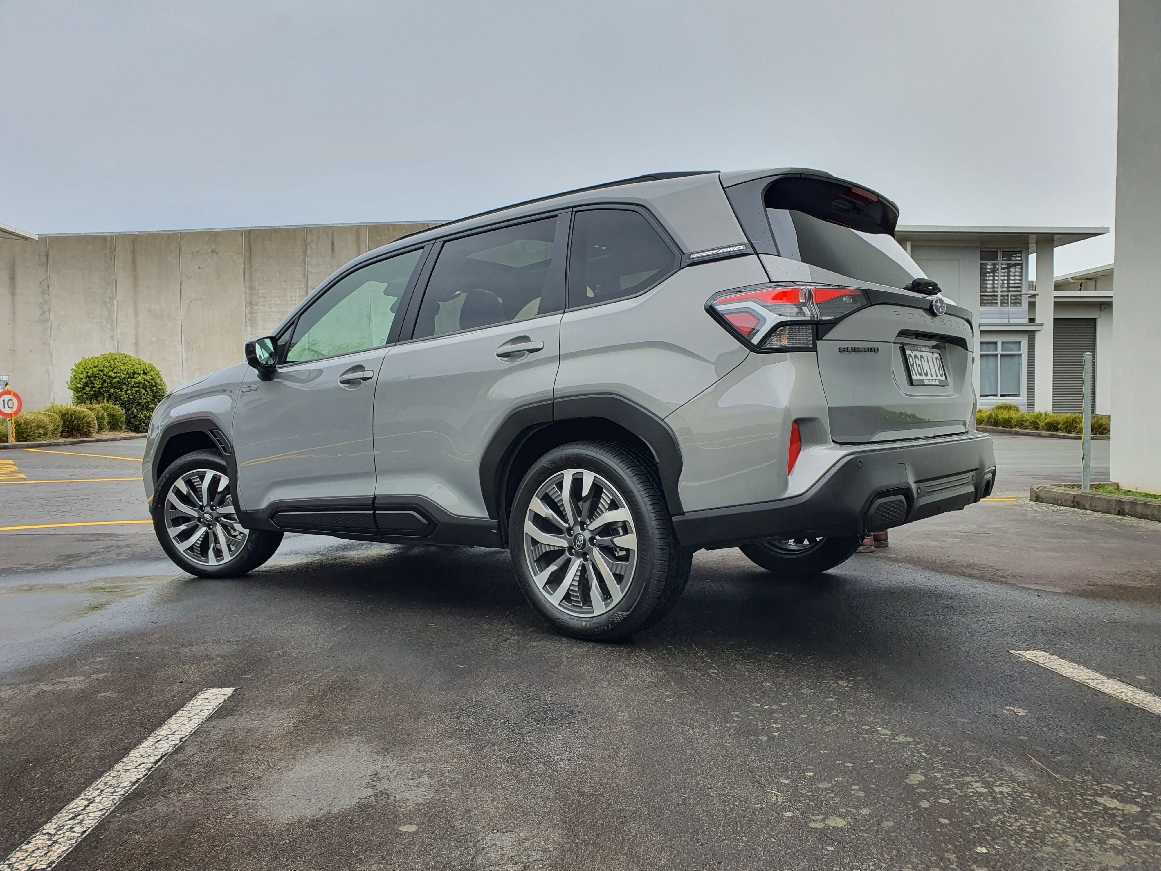 Rear three quarters view of a 2025 Subaru Forester AWD Touring Hybrid in River Rock Pearl.