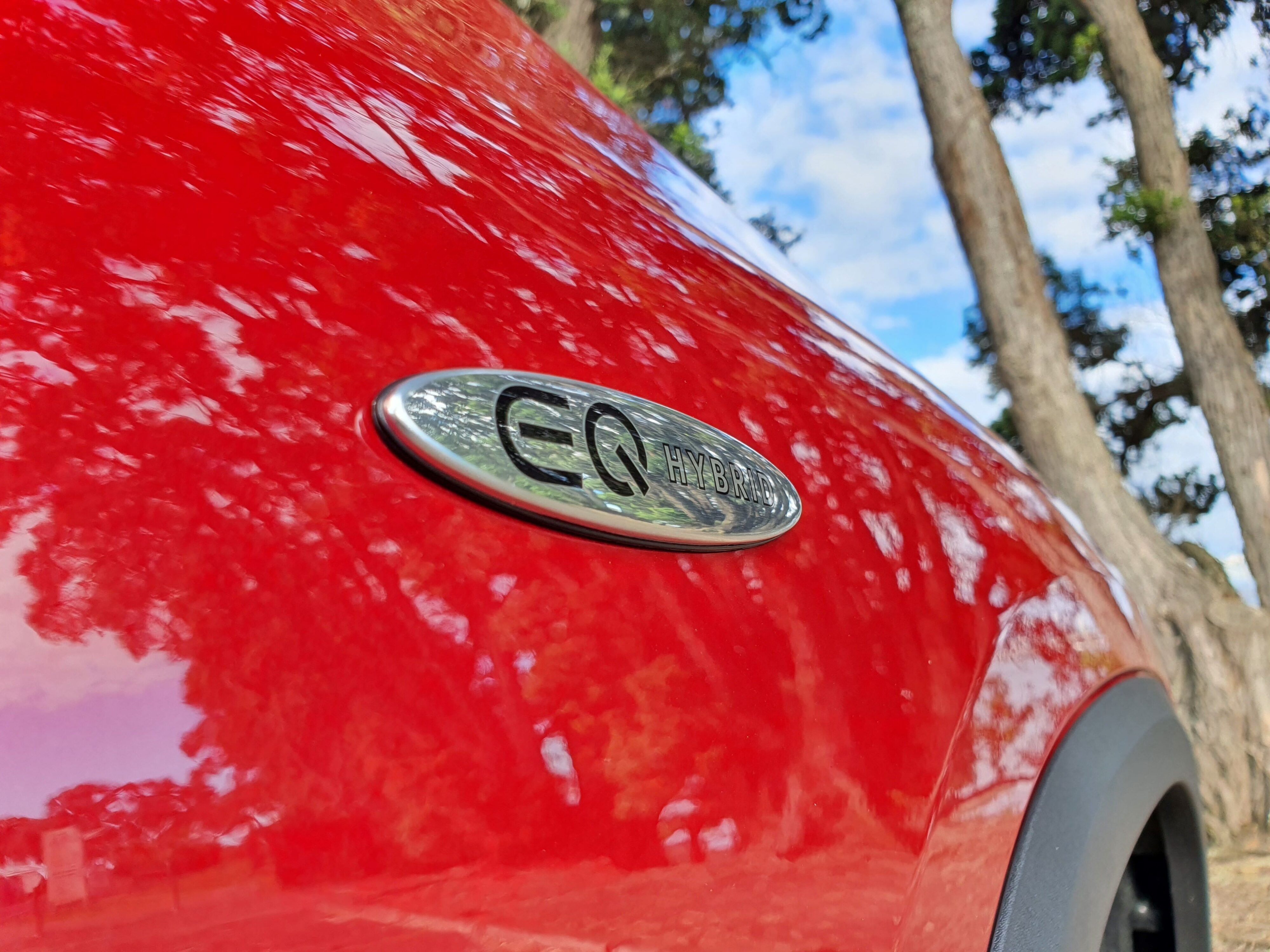 Close up of the EQ Hybrid badge on the side of a 2025 Mercedes-Benz GLA250e in Patagonia Red Metallic.