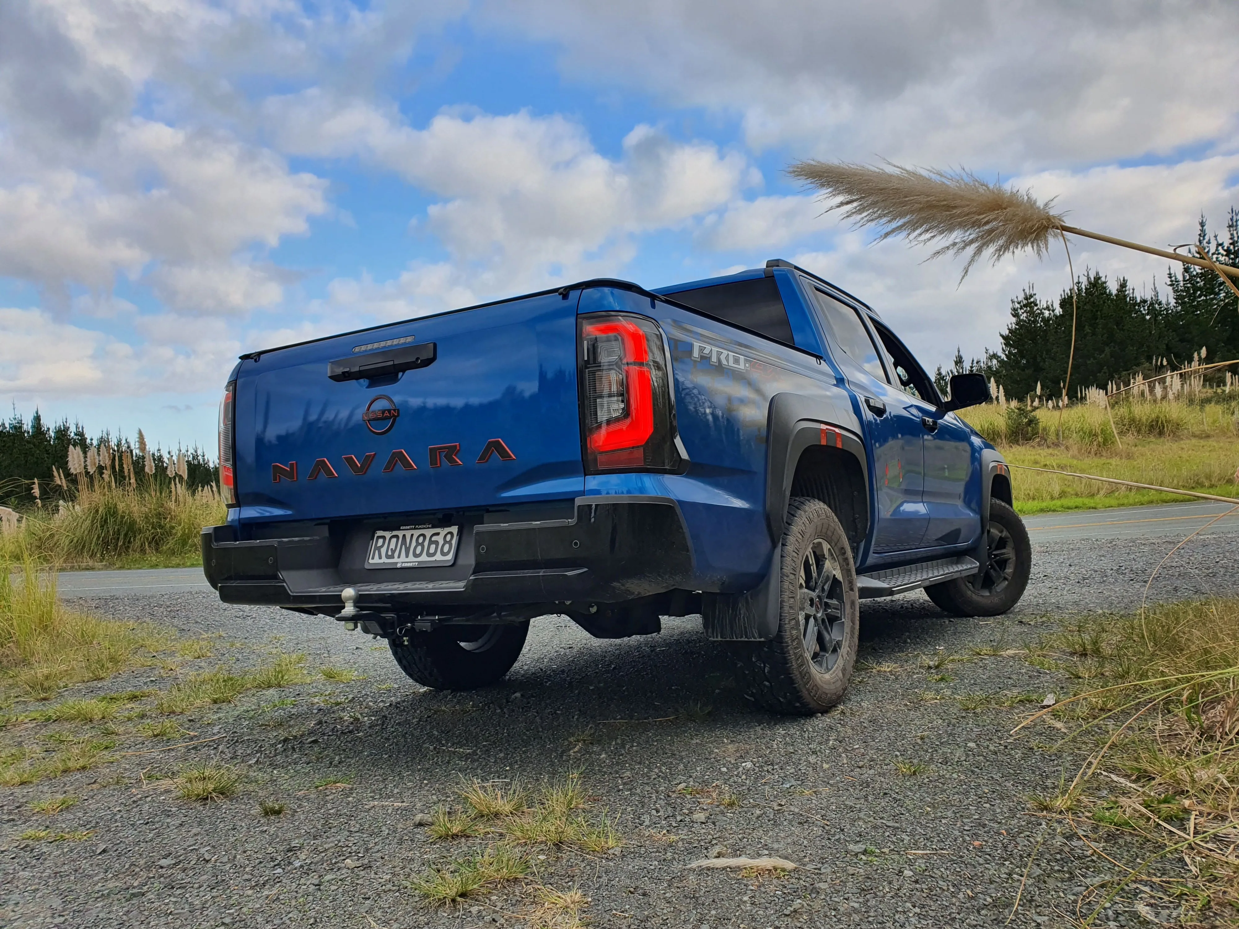 Low angle rear three quarters view of a 2026 Nissan Navara Pro-4X in Horizon Blue.