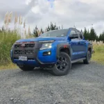 Low angle front three quarters view of a 2026 Nissan Navara Pro-4X in Horizon Blue.