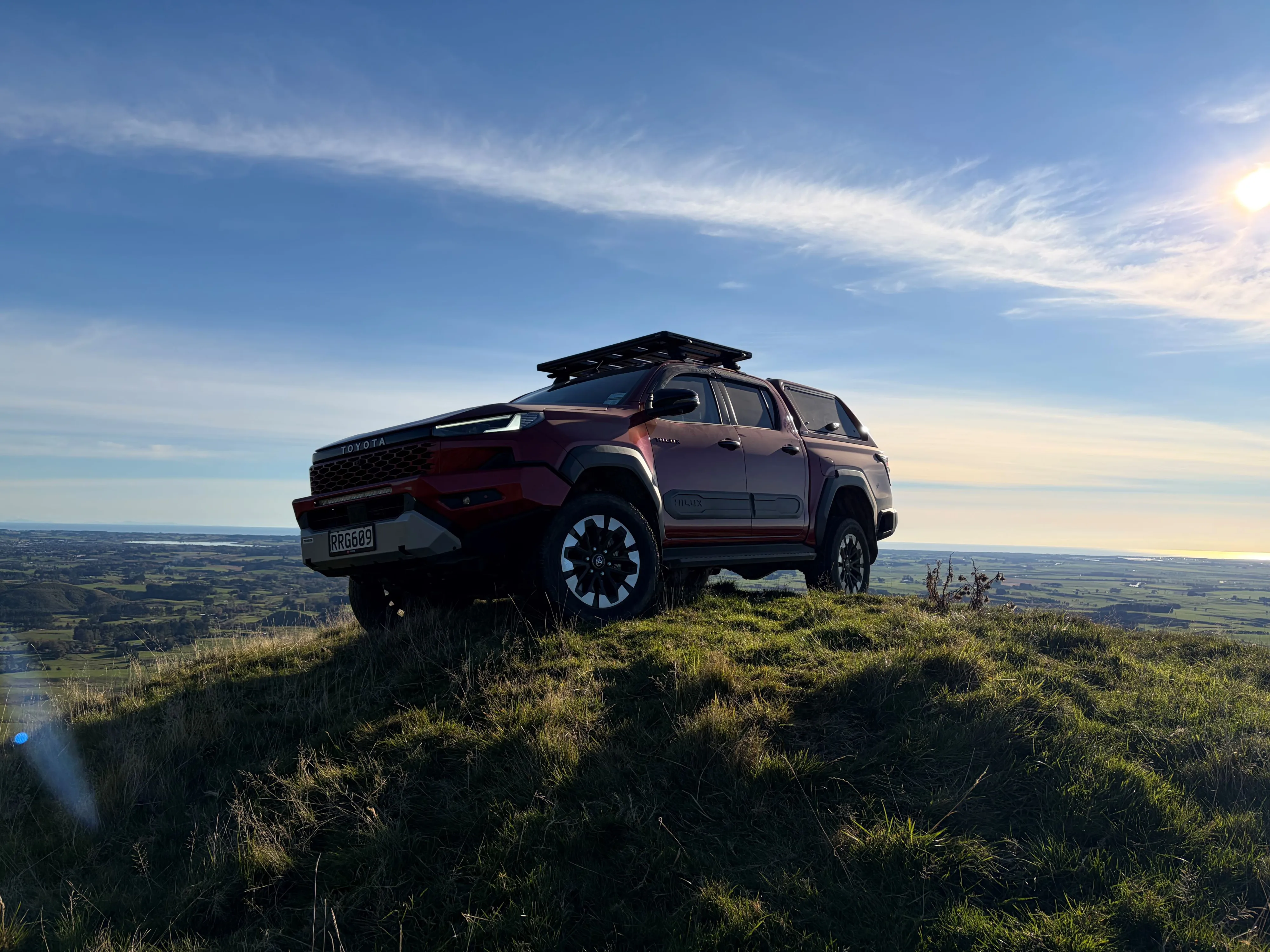 A 2026 Toyota Hilux SR5 in 'Emotional Red' perched atop a hill, taken at Heights Experience on the New Zealand launch of the ninth-generation Hilux in Manawatu, New Zealand.