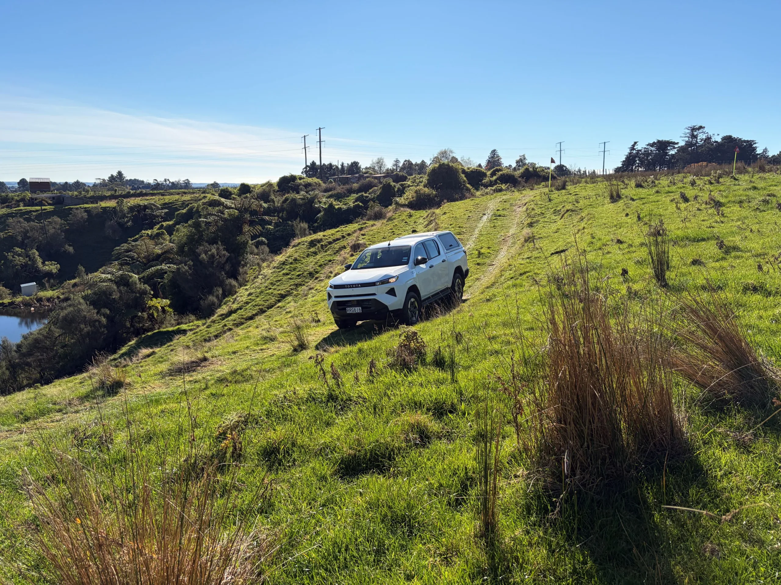 A 'Glacier White' 2026 Toyota Hilux BEV goes off-road on the New Zealand launch of ninth-generation Toyota Hilux, taken at Heights Experience in Manawatu, New Zealand.