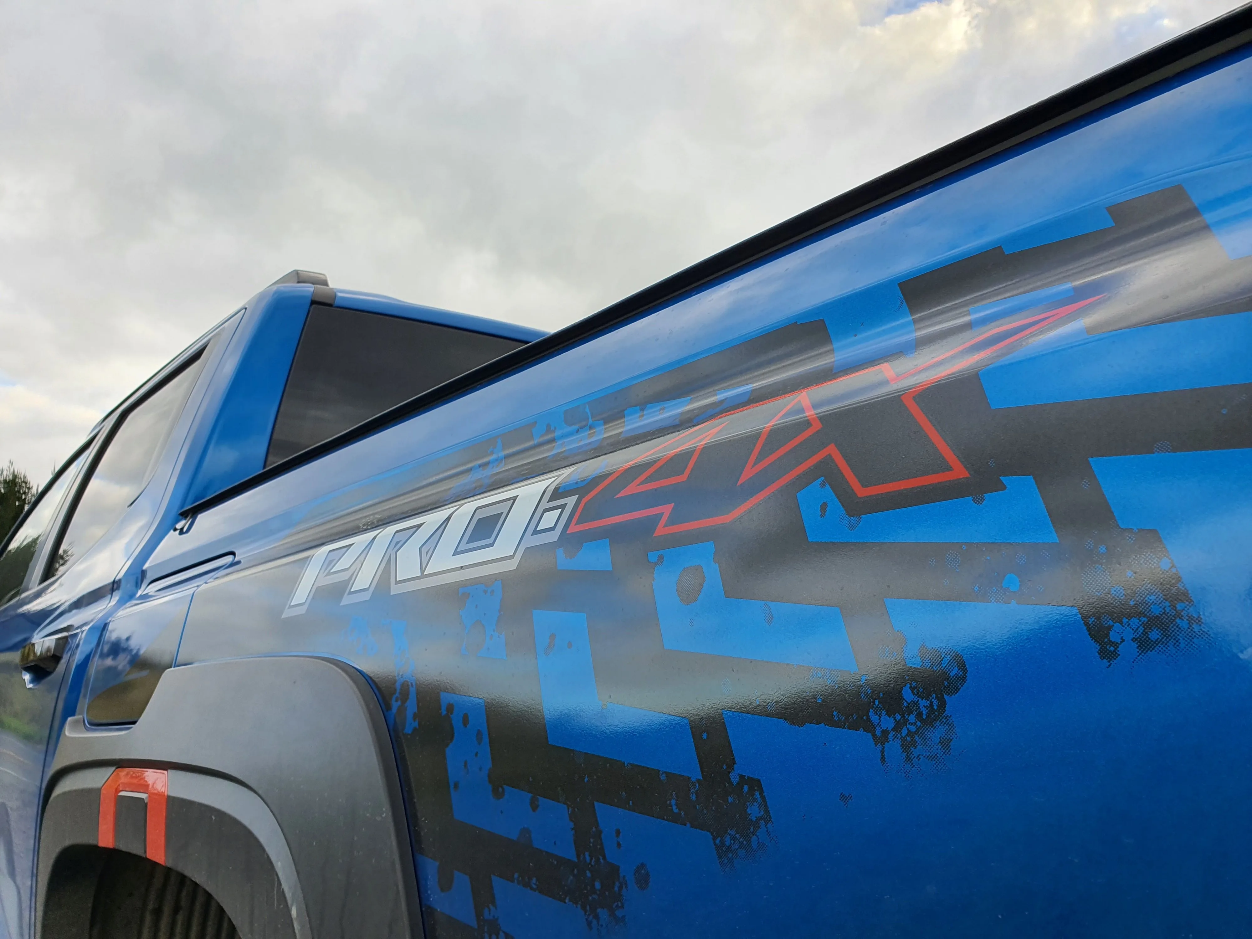 Close up of the Pro-4X badge on the rear three quarters of a 2026 Nissan Navara Pro-4X in Horizon Blue.