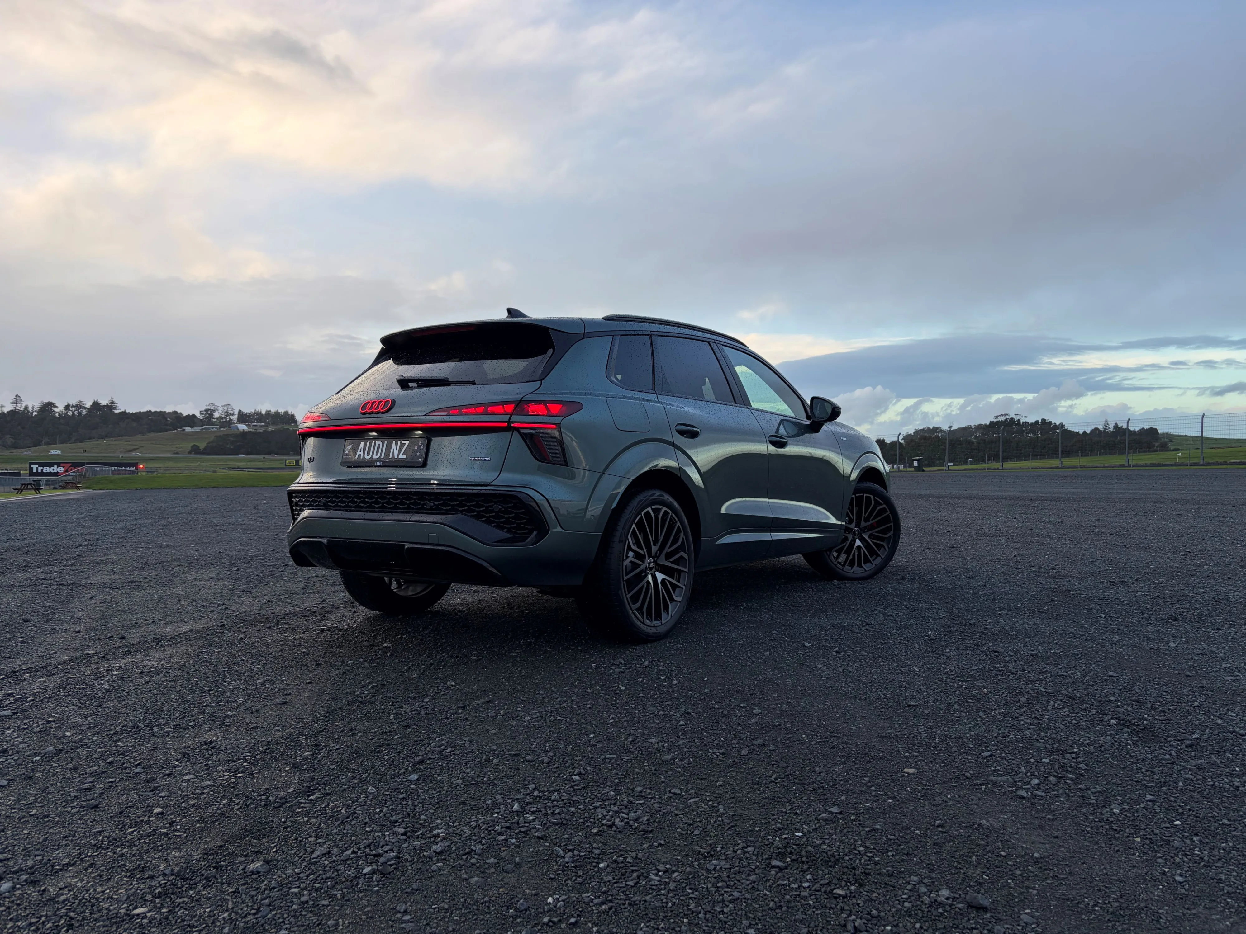 Rear three quarters view of a 2026 Audi Q3 195kW S-Line quattro in Sage Green, photographed at sunset.