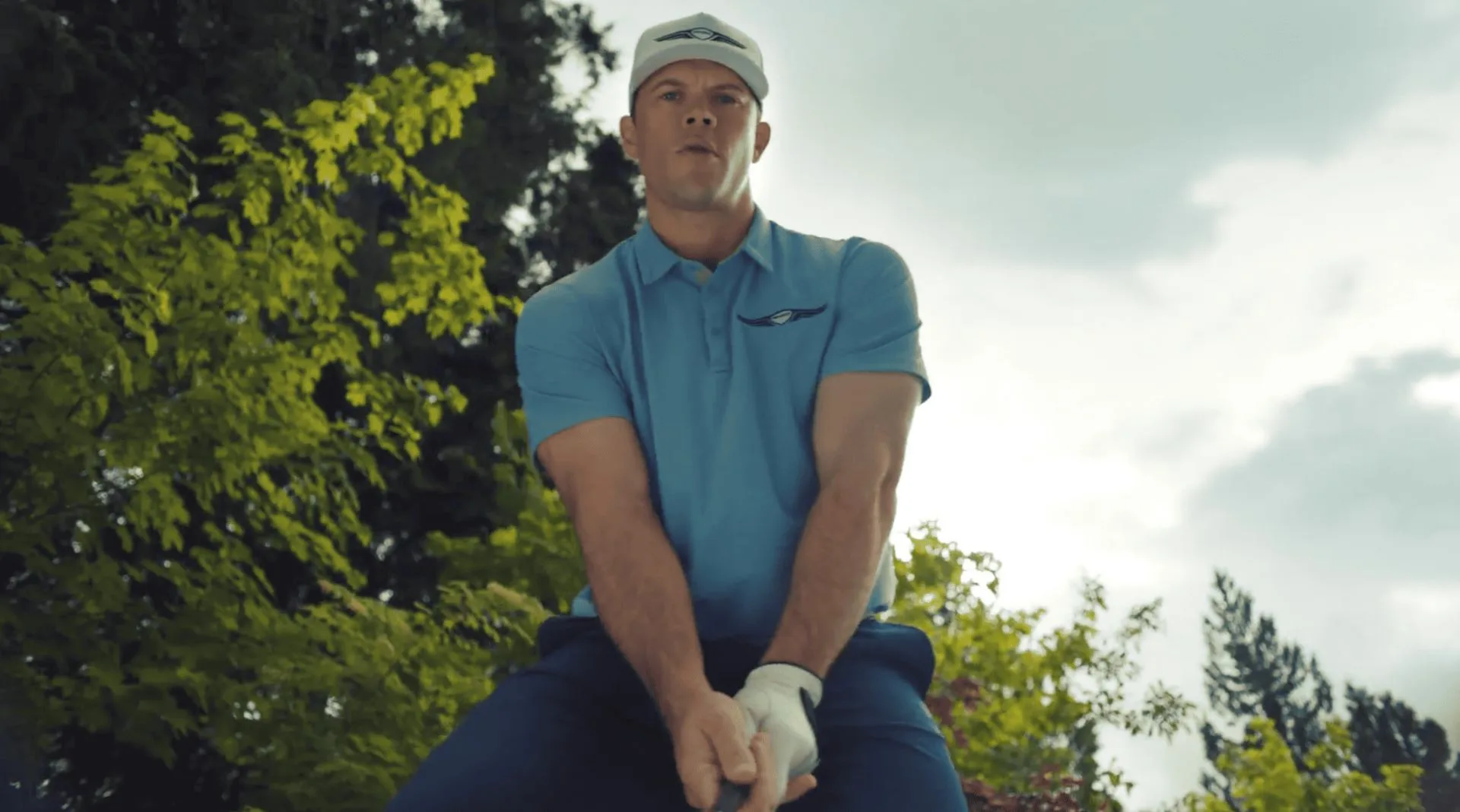 A photo of Jimmy Tatro dressed in Genesis branded golf clothing in a scene from Netflix's 'The Hawk' series.