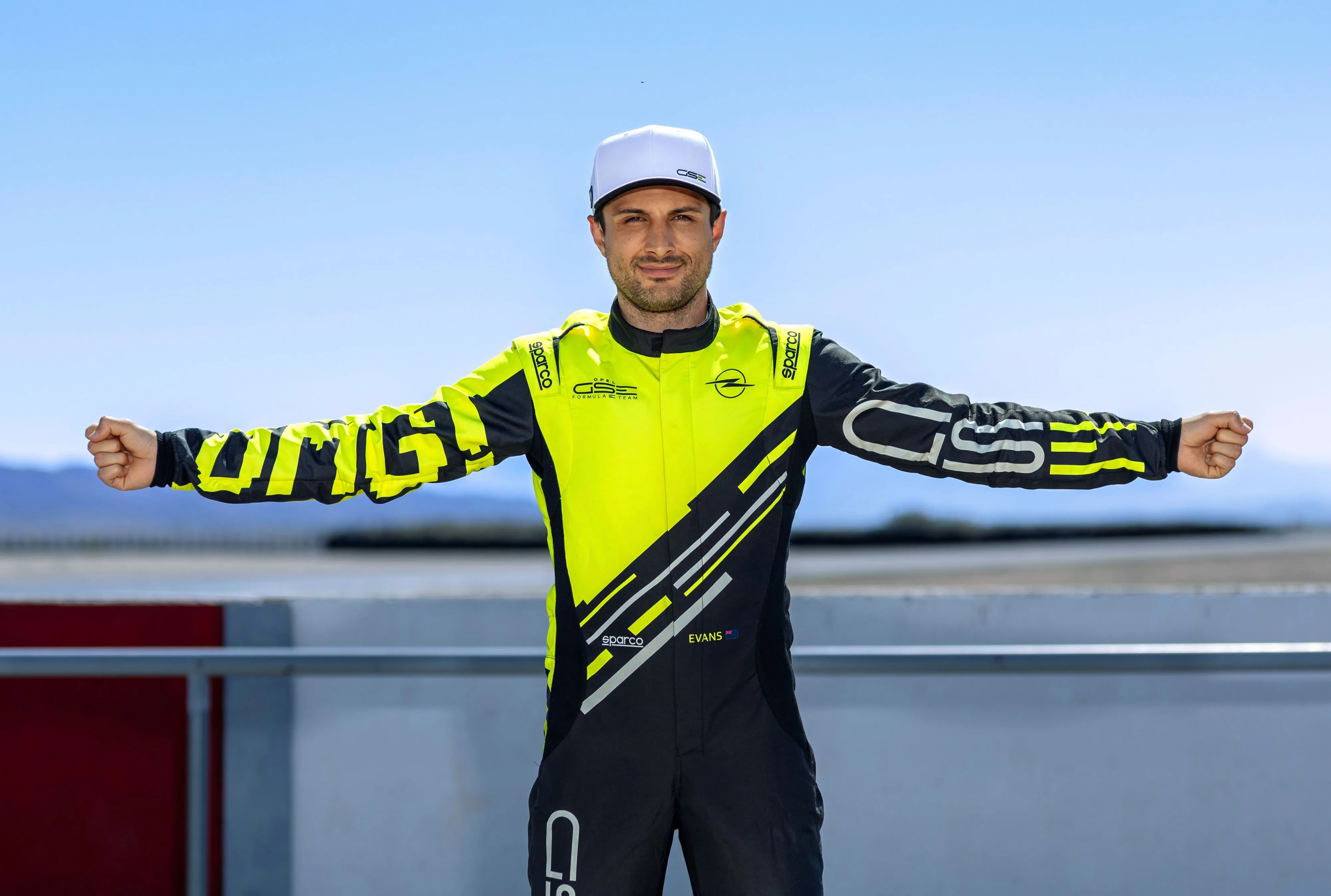 Mitch Evans posing while dressed in the colours of the Opel GSE Formula E Team.