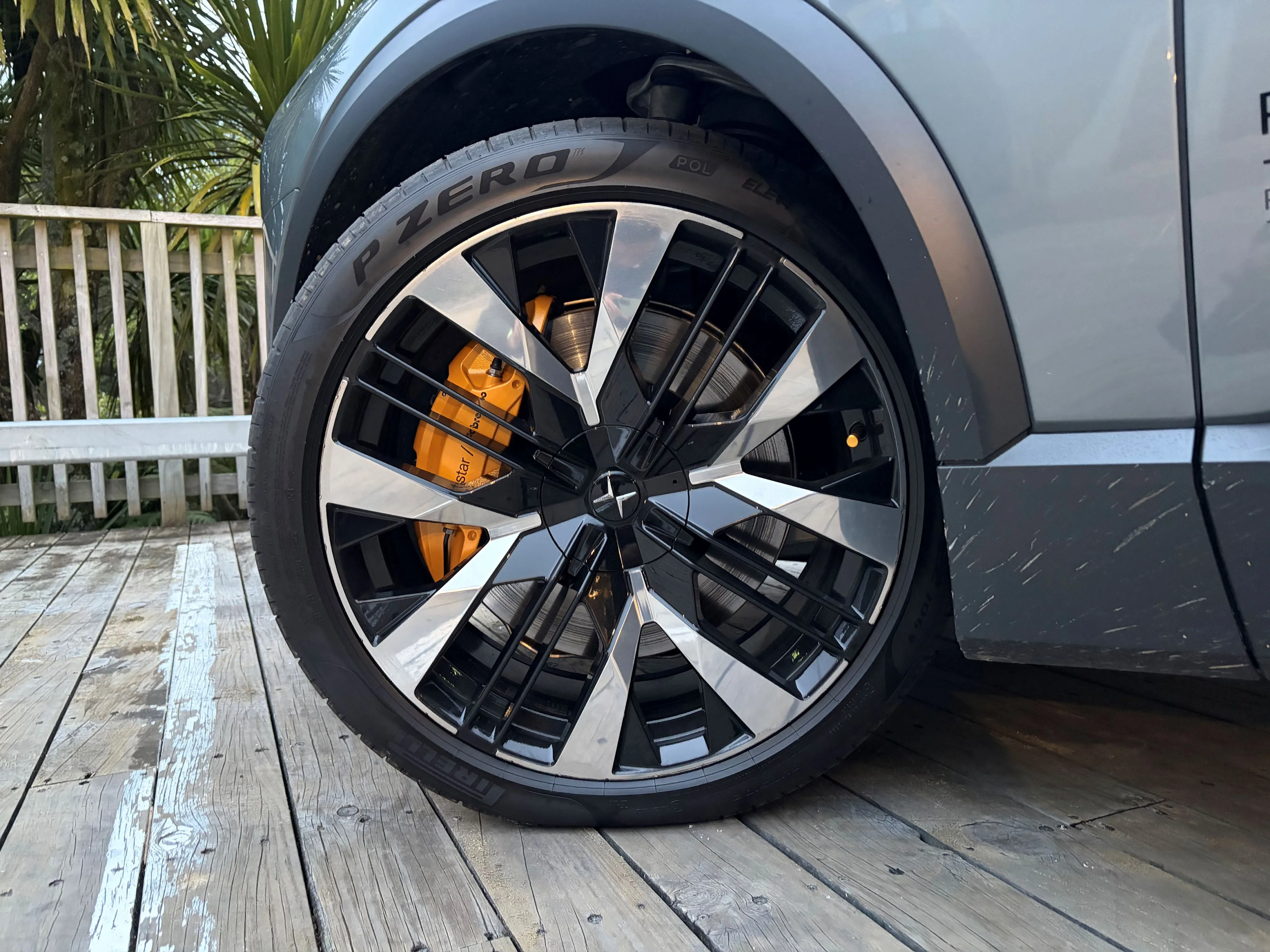 Photo of the 23 inch front left wheel of a 2026 Polestar 3 Performance with its 'Swedish Gold' Brembo brake caliper visible.