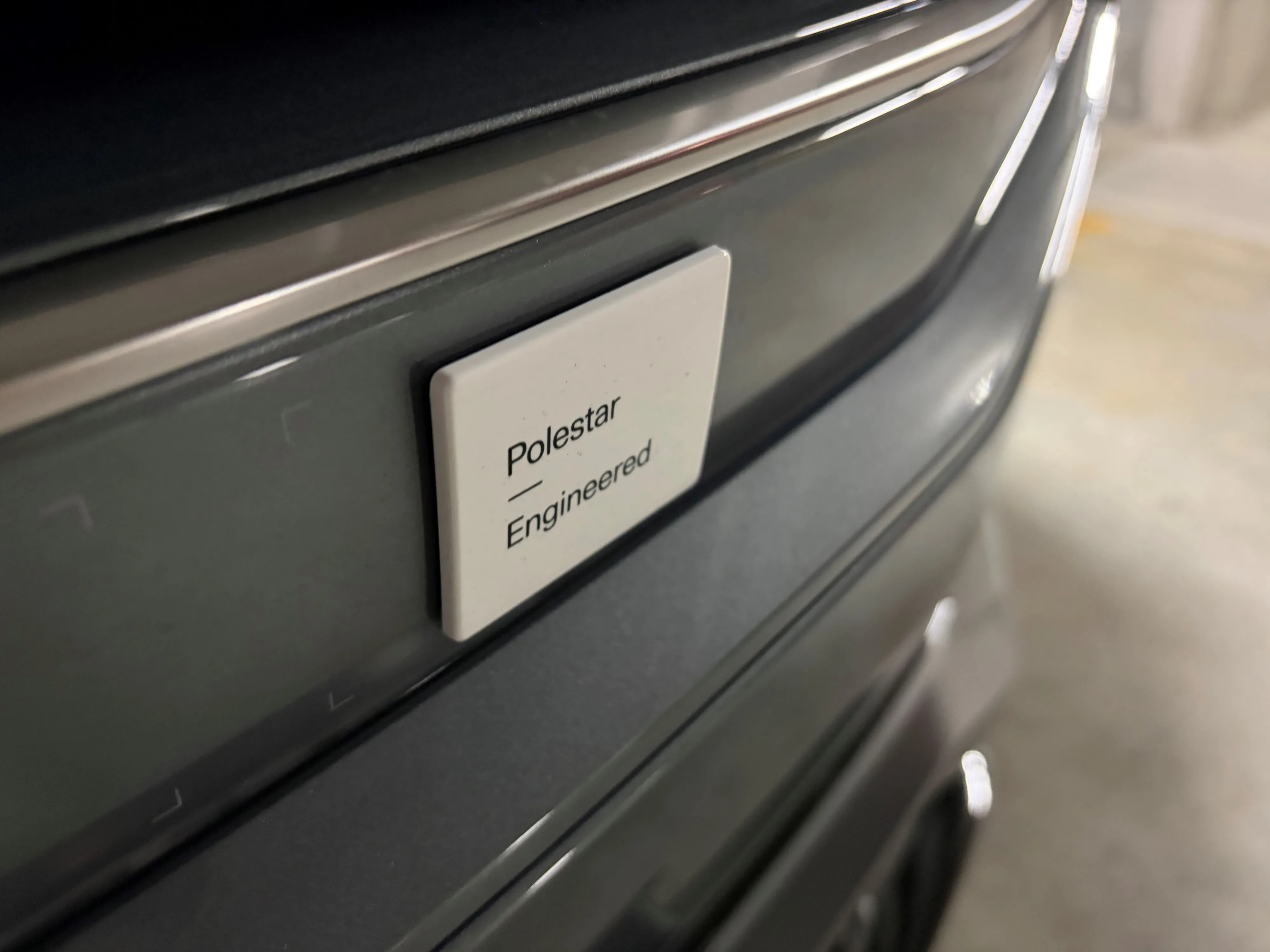 Close-up of the 'Polestar Engineered' badge on the nose of a 2026 Polestar 3 Performance in Storm.
