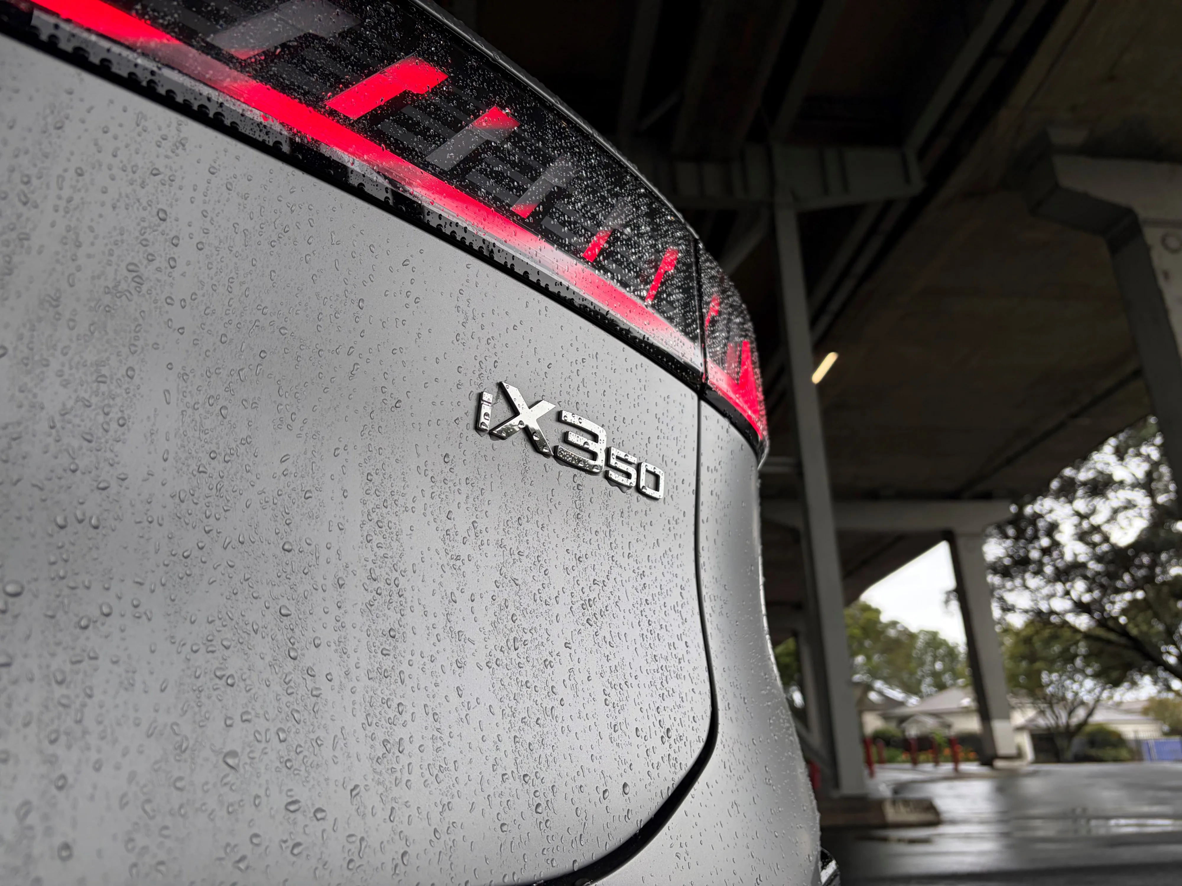 Close up of the iX3 50 badge on the rear of a 2026 BMW iX3 50 in Frozen Space Silver metallic, photo taken under Auckland's Harbour Bridge.