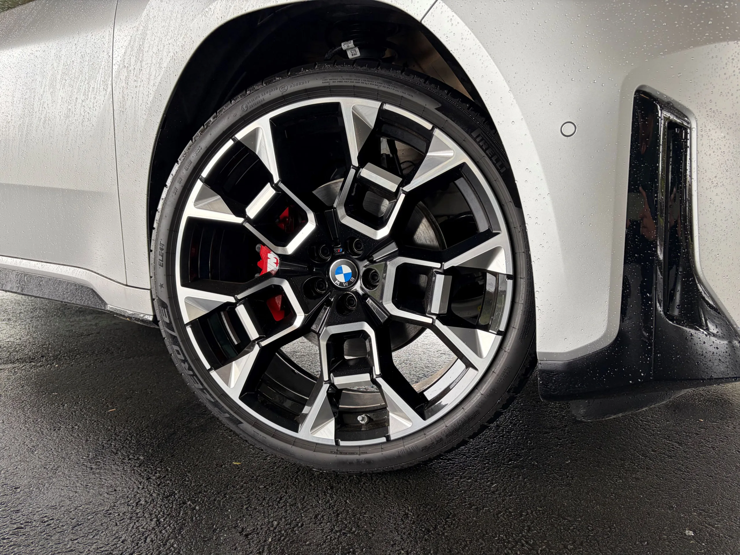 Close up of the front right 22 inch wheel on a 2026 BMW iX3 50 in Frozen Space Silver metallic.