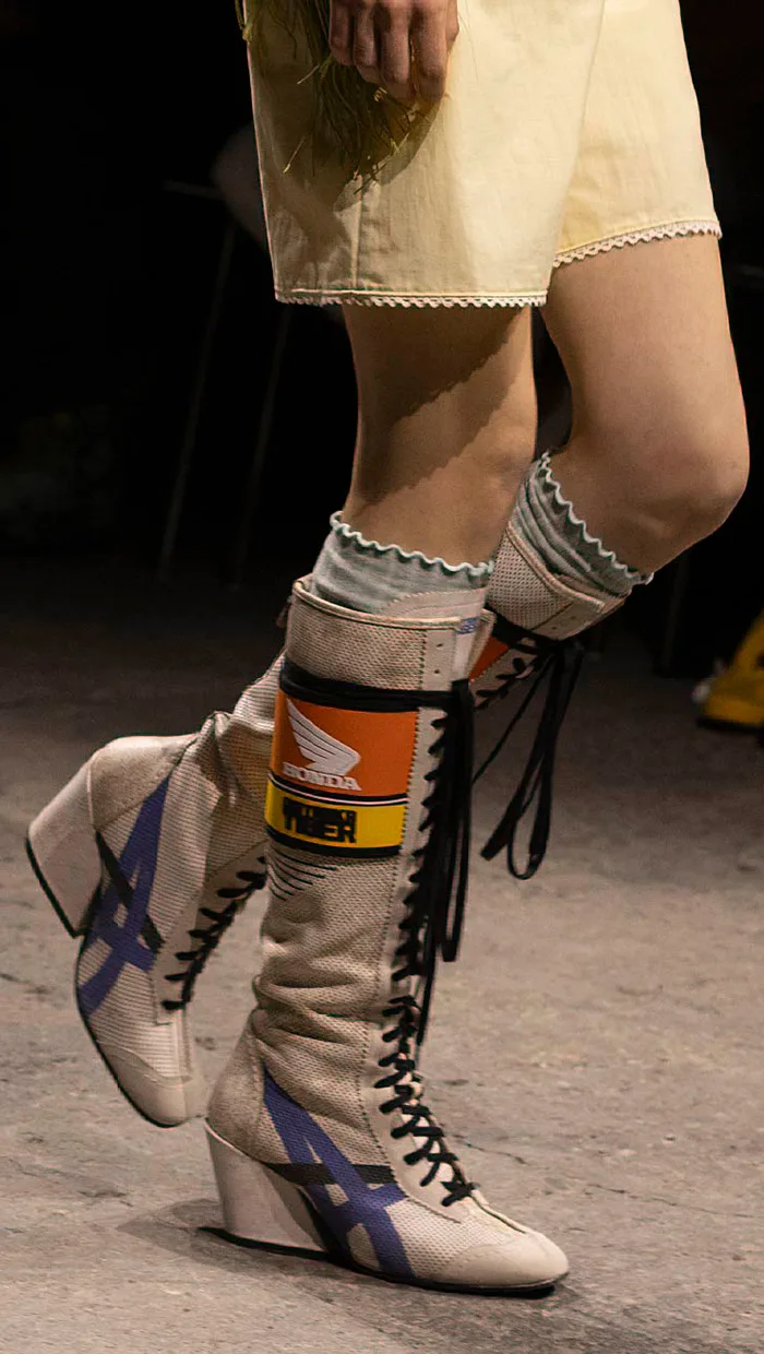 Photo of a model wearing Onitsuka Tiger x Honda boots during a fashion show.