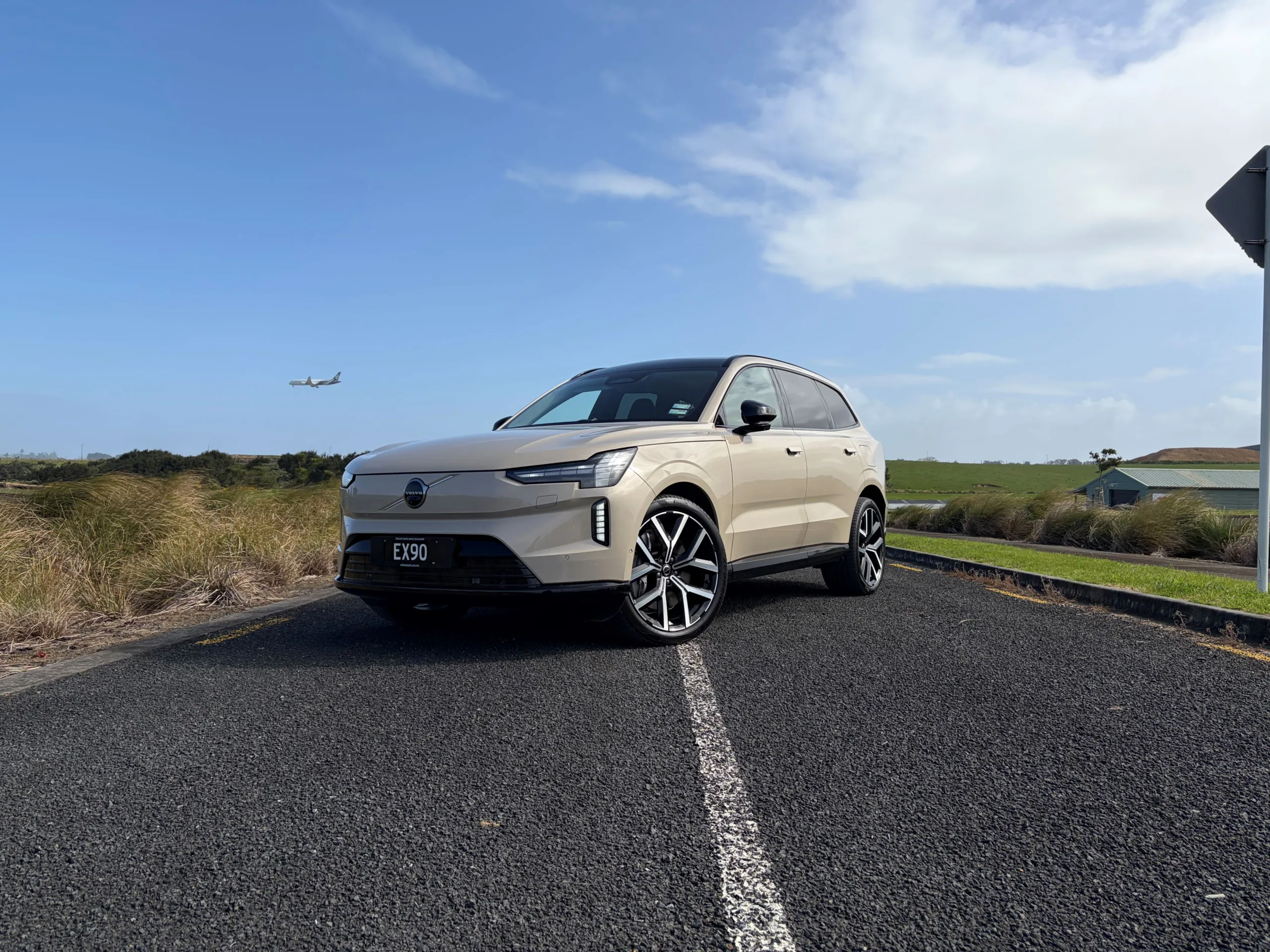 Front three quarters view of a 2026 Volvo EX90 Ultra Twin Motor Performance in Sand Dune with a natural background.